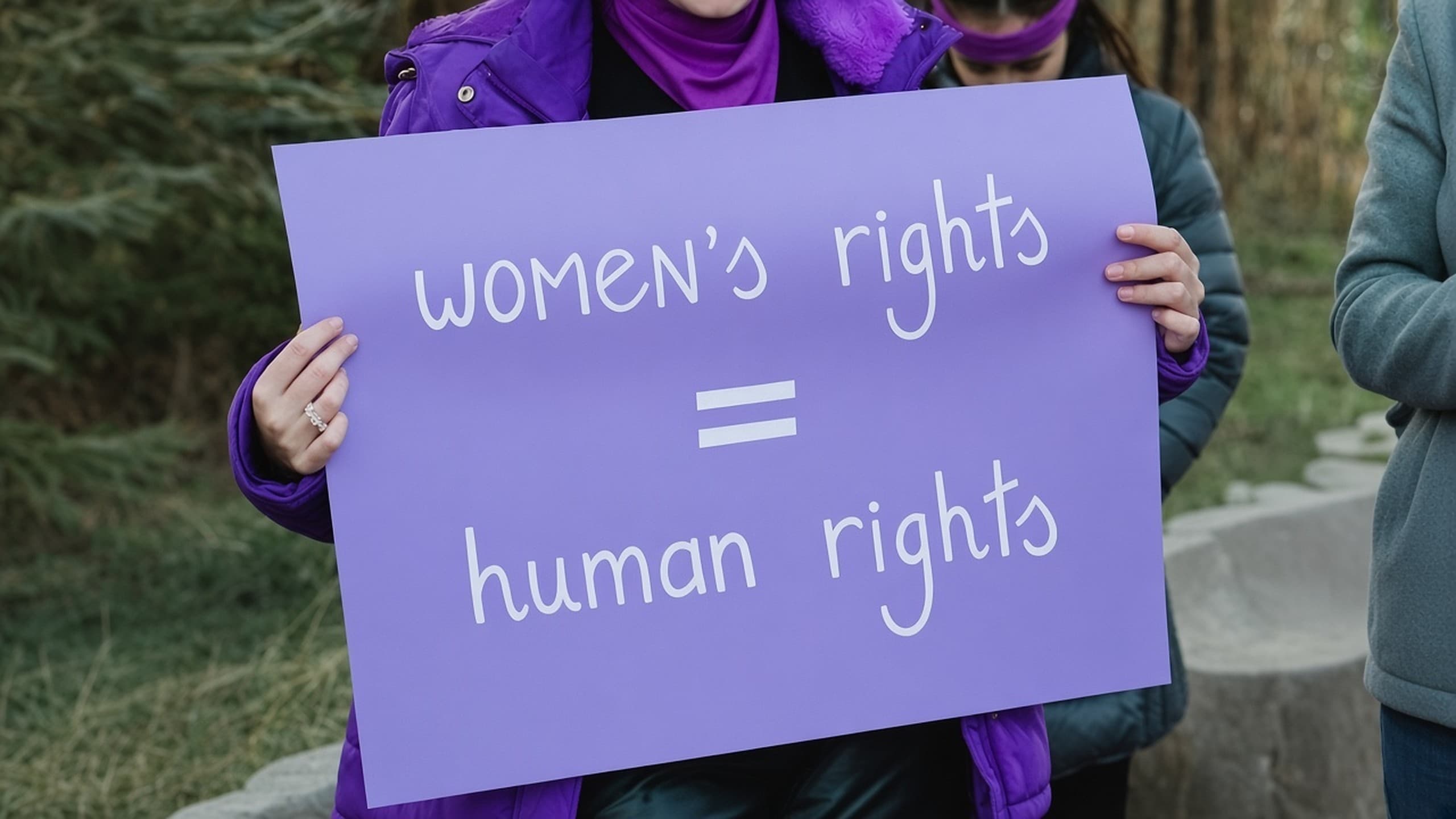 Lila Schild mit der Aufschrift „women’s rights = human rights“